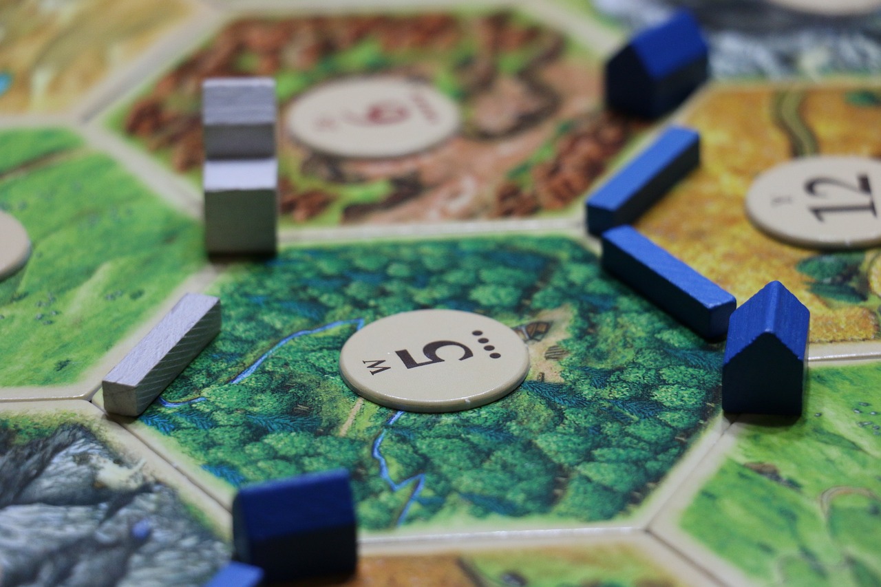 a close up picture of a field with buildings in Catan Image source: https://pixabay.com/photos/game-board-catan-leisure-340574/